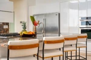 Contemporary kitchen with white cabinets, stainless steel appliances, and a breakfast bar.