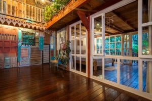 Interior view of a sustainable home with wooden floors and large glass doors.