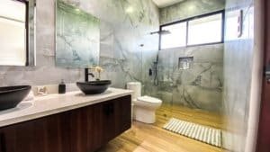 Modern bathroom with marble walls, dual sinks, and mountain view window.