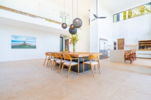 Spacious dining area with high ceilings, modern decor, and large windows.