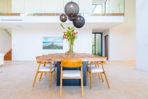 Spacious tropical dining room with wooden table and modern decor.