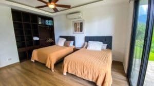 Spacious bedroom with two beds, mountain view, and modern decor in Dominical.