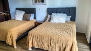 Bedroom with two twin beds, beige bedding, and modern decor in Dominical.