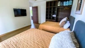 Bedroom with two beds, ocean view, and modern decor in Dominical.