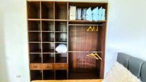 Large wooden closet with shelves and hanging space in a bedroom.
