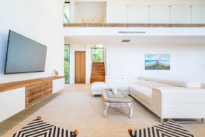 Bright, spacious living room with white sofa and ocean view artwork.