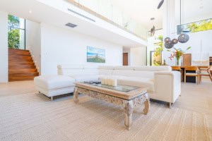 Bright, spacious living room with white sofa and large windows in Costa Rica.