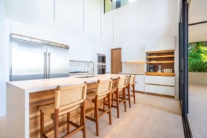 Bright modern kitchen with island, white cabinets, and wooden accents.