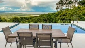 Outdoor dining area overlooking ocean and lush green mountains in Dominical.