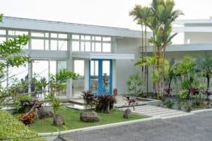 Contemporary Costa Rican house with lush tropical garden and pathway.