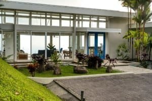 Contemporary house with lush tropical garden and large glass windows in Dominical.
