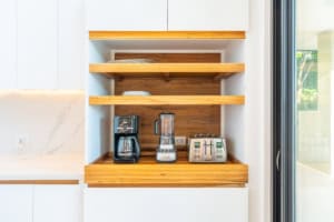Kitchen shelf with coffee maker, blender, and toaster in a modern home.