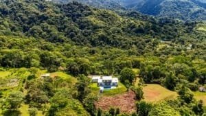 Panoramic view of a luxury home in Dominical surrounded by lush forest and mountains.