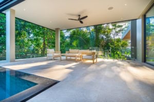 Spacious indoor lounge with large glass windows and tropical views.