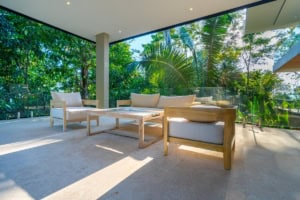 Modern outdoor living space with tropical greenery and ocean view.
