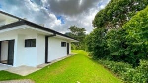 Modern Costa Rican home with panoramic ocean and mountain views surrounded by greenery.