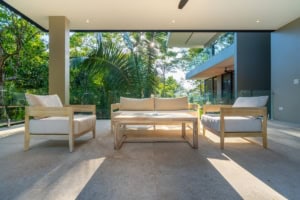 Spacious tropical living room with outdoor view and modern furniture.