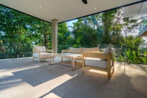 Spacious outdoor terrace with modern furniture and lush tropical scenery.