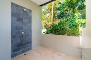 Outdoor shower with lush tropical garden view in Dominical, Costa Rica.