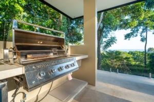 Modern outdoor kitchen with grill and ocean view in Dominical, Costa Rica.