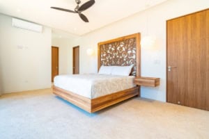 Modern bedroom with wooden accents, ocean view, and stylish decor.