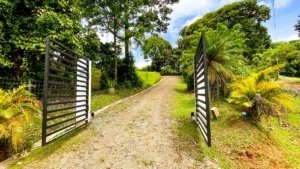 Gated driveway leading to lush tropical landscape in Dominical, Costa Rica.