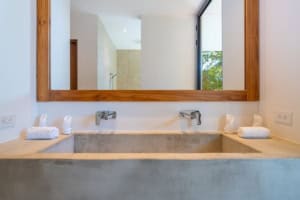 Contemporary bathroom with double sinks, large mirror, and natural light.