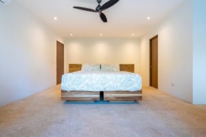 Spacious bedroom with minimalist decor and ceiling fan in Costa Rica.