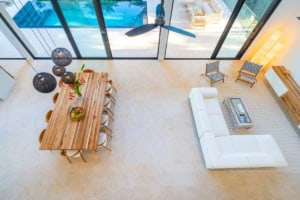 Spacious living room with ocean view, modern furniture, and large glass doors.