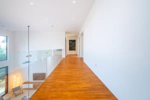 Bright, spacious hallway with wooden flooring and white walls in Costa Rica.