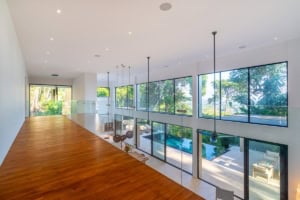 Bright interior with large windows overlooking lush greenery and pool.