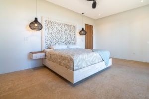 Modern bedroom with tropical decor, large bed, and ocean view in Dominical.