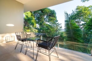 Balcony overlooking lush tropical forest with outdoor seating in Dominical, Costa Rica.