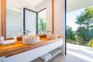 Modern bathroom with dual sinks and ocean view balcony in Costa Rica.
