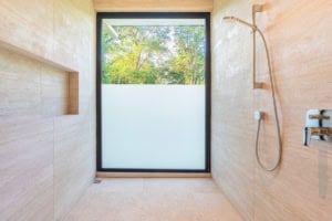 Bright bathroom with large window overlooking lush greenery in Costa Rica.