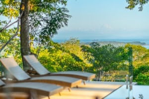 Scenic ocean view from tropical home with pool and lounge chairs in Dominical.