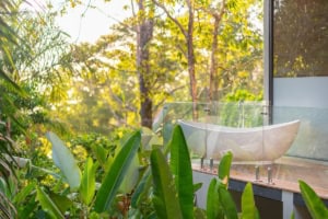 Modern bathroom with bathtub overlooking lush tropical forest in Dominical.