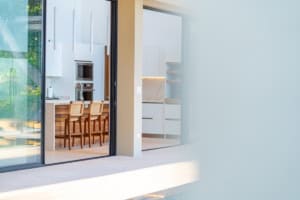 Bright modern kitchen and living space with large glass doors and ocean view.