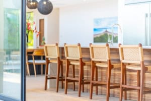 Modern kitchen with ocean view, wooden bar, and high chairs in Dominical.