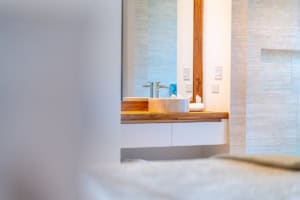 Contemporary bathroom with wooden vanity and neutral tiles.