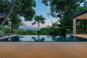 Ocean view infinity pool with lush tropical trees in Dominical, Costa Rica.