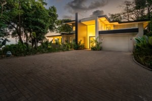 Modern tropical house with illuminated interior and lush garden in Dominical.