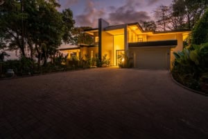 Modern tropical home with ocean view, illuminated at dusk in Dominical, Costa Rica.