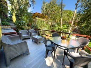 Outdoor patio with chairs, table, and tropical greenery in Dominical, Costa Rica.