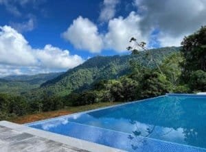 Infinity pool overlooking lush mountains and cloudy sky in Costa Rica.