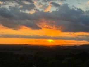 Beautiful sunset view with vibrant orange and yellow colors over lush landscape in Dominical.