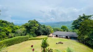 Scenic view of mountain estate with lush greenery and waterfall in Costa Rica.