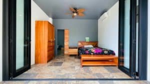 Bright bedroom with large glass doors and mountain view in Dominical.