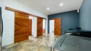 Spacious garage with wooden sliding doors and tiled floor in Costa Rica.