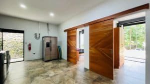Spacious room with sliding wooden doors and modern kitchen appliances.